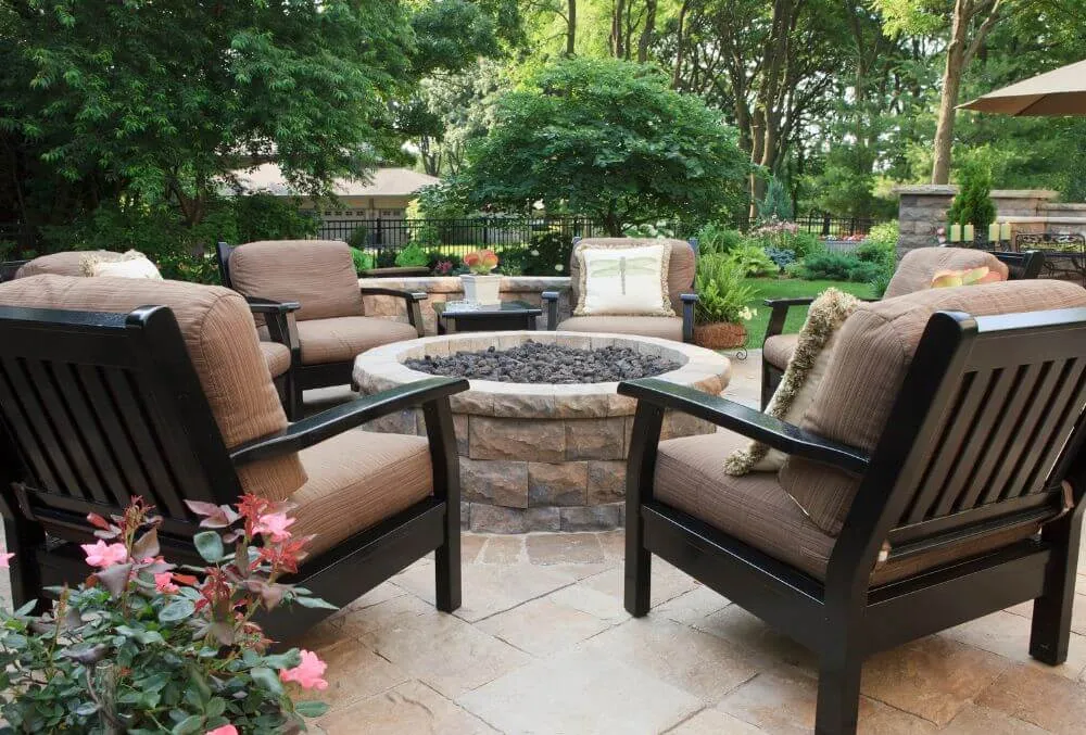 patio with chairs and a firepit at the center