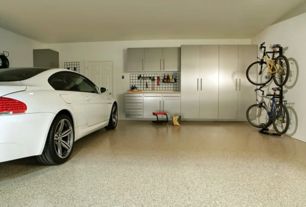 A white car parked and two bicycles in a concrete residential garage