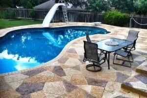 Stamped concrete pool deck with lounge chairs nearby