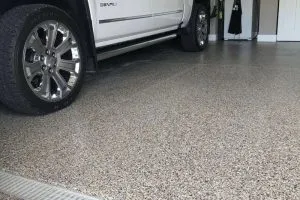 epoxy flooring garage beneath a white car